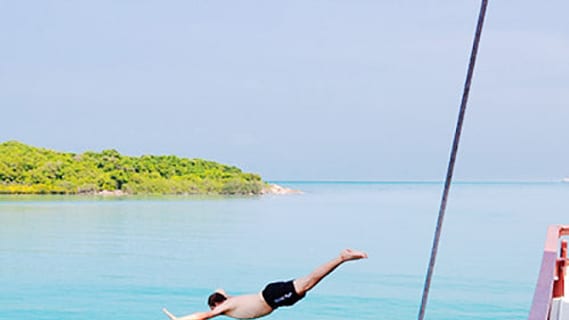 Sprung ins türkisblaue Wasser vor der Küste von Koh Phangan