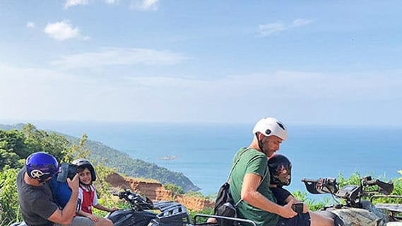 Quad-Fahrer an einem Aussichtspunkt im Hinterland von Koh Samui mit Blick aufs Meer