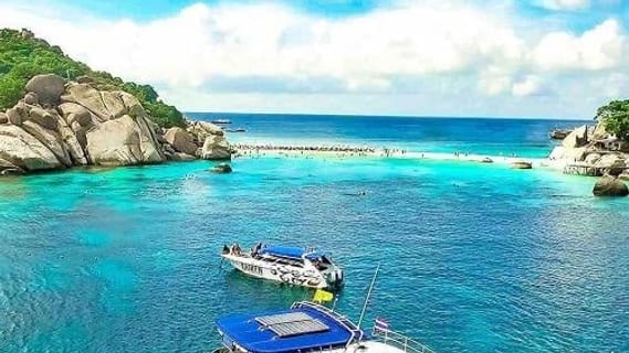 Ausflugsboote über einem türkisblauen Riff bei einer Schnorcheltour vor Koh Samui